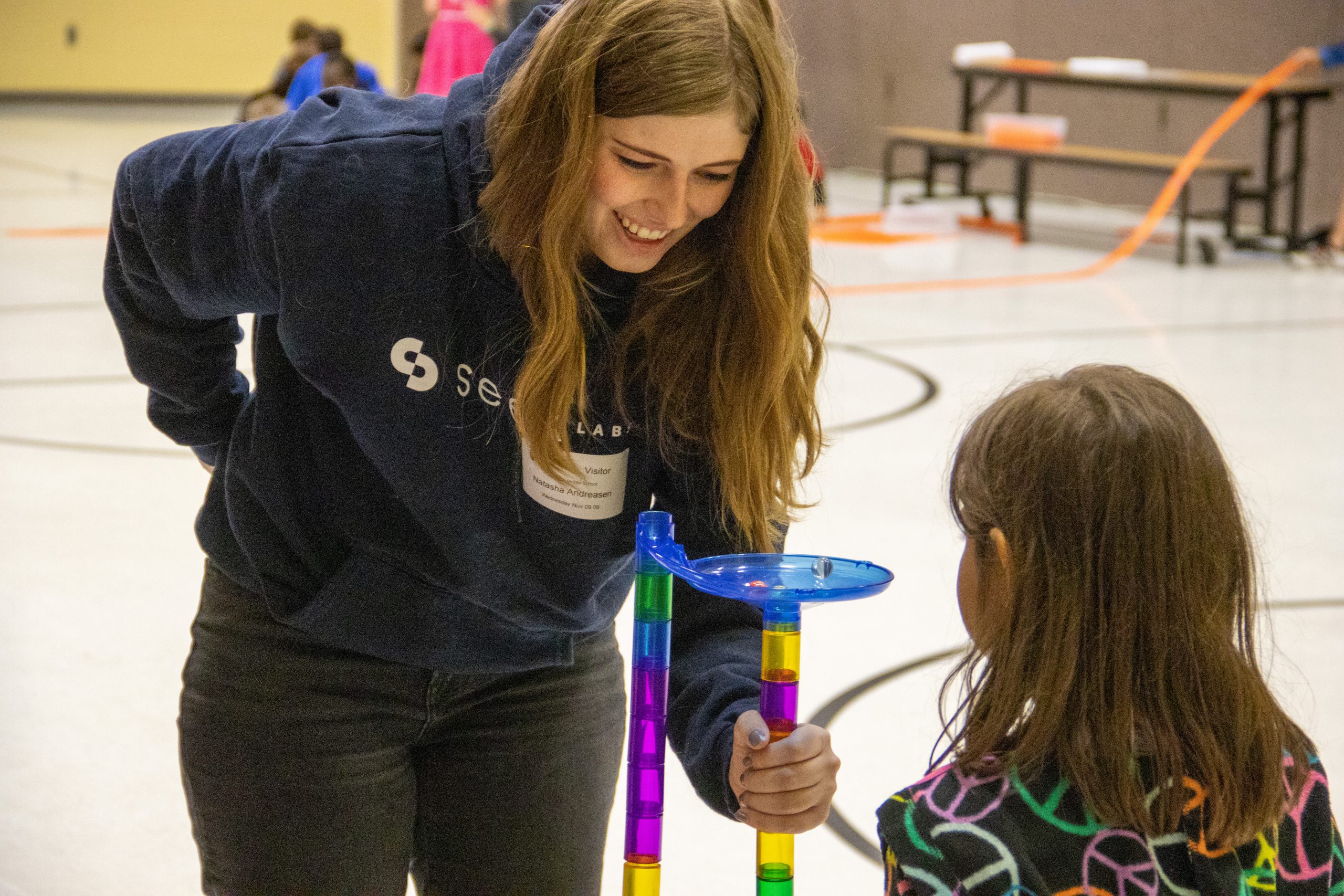 Adult volunteers helping kids at a Micro STEM Fest event.