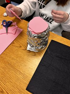 a student making a cooler out of aluminum foil and foam